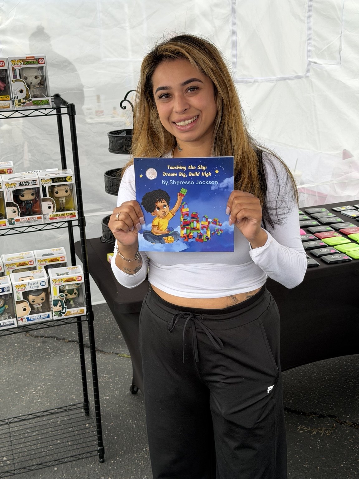 Reader holding Touching the Sky at a community event